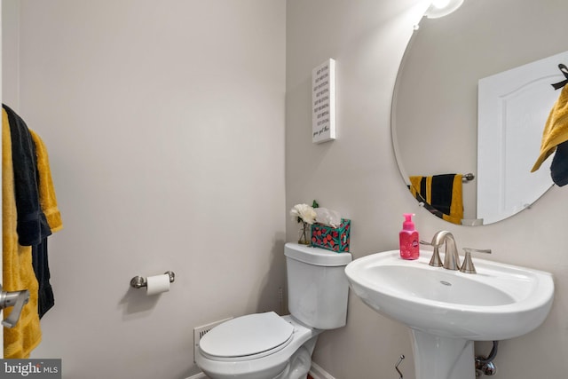 bathroom featuring baseboards, a sink, and toilet