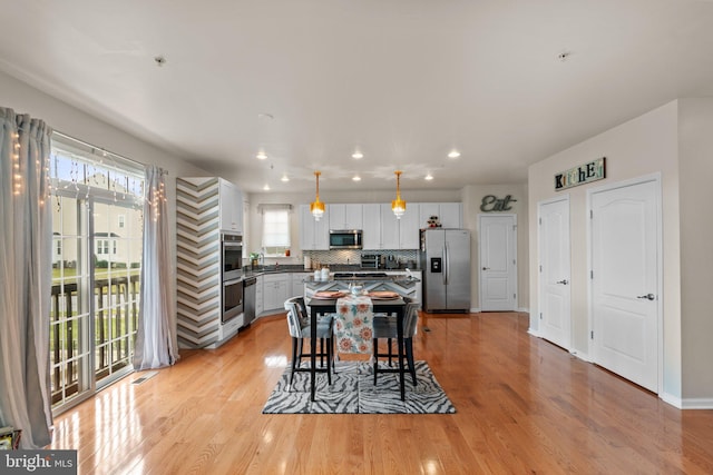 dining area featuring recessed lighting, baseboards, visible vents, and light wood finished floors