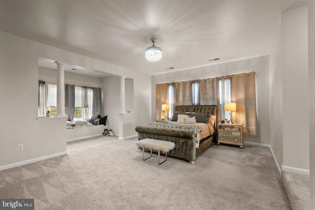 carpeted bedroom featuring baseboards, visible vents, and ornate columns