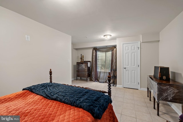 bedroom with light tile patterned floors and baseboards