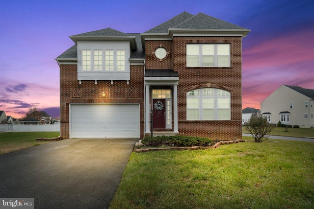 view of front facade featuring driveway, a garage, a shingled roof, a yard, and brick siding