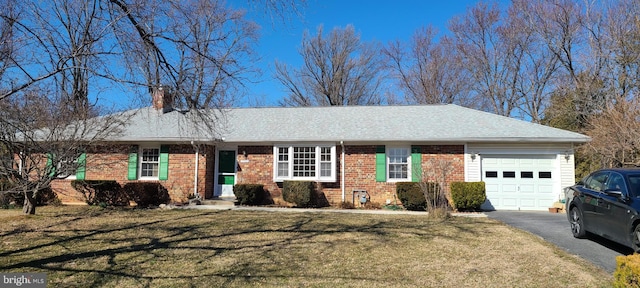 ranch-style home featuring brick siding, a front lawn, a chimney, a garage, and driveway