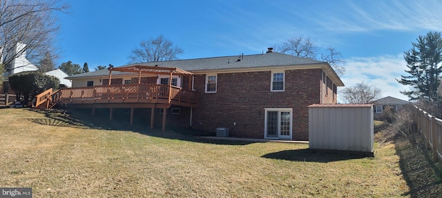 back of house featuring fence, a wooden deck, a yard, a pergola, and brick siding