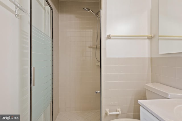 bathroom featuring vanity, toilet, tile walls, and a shower stall