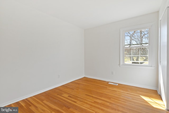 unfurnished room featuring visible vents, baseboards, and light wood-style flooring