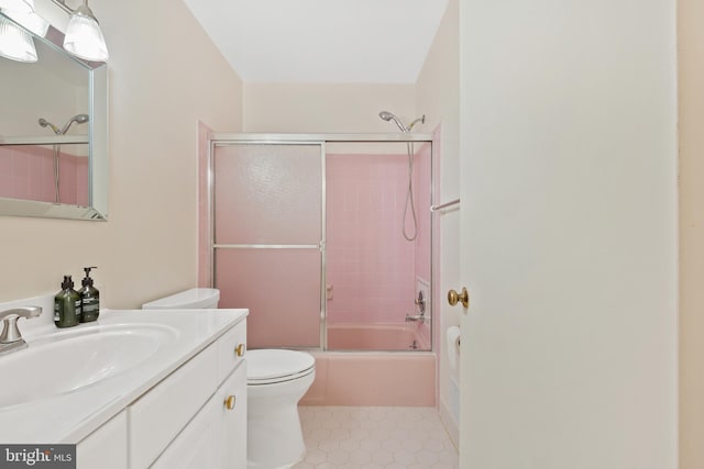 bathroom featuring shower / bath combination with glass door, toilet, vanity, and tile patterned floors