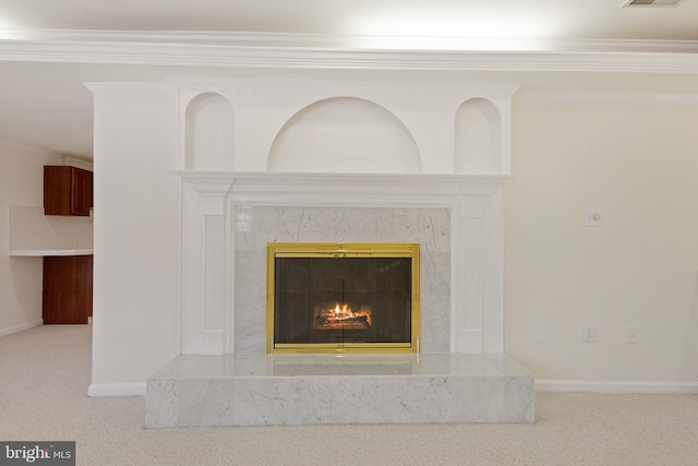 interior details with baseboards, visible vents, carpet floors, a premium fireplace, and ornamental molding