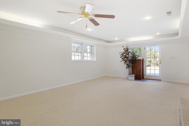 unfurnished room with crown molding, a raised ceiling, and baseboards