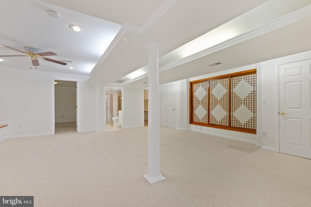 basement featuring visible vents, baseboards, ceiling fan, ornamental molding, and light carpet