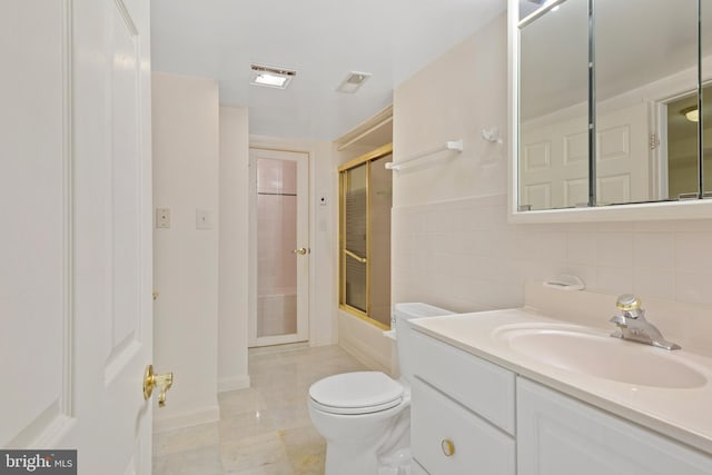 full bathroom featuring vanity, tile walls, toilet, and visible vents