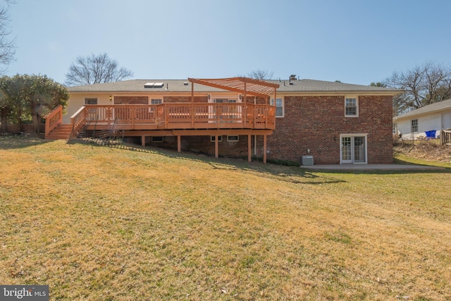 rear view of property with a lawn, a deck, brick siding, and a pergola