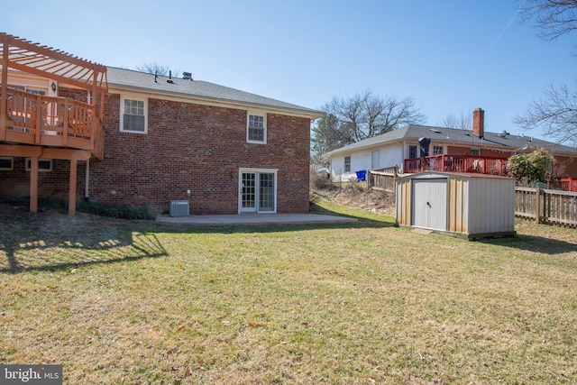 rear view of house featuring an outbuilding, a pergola, a patio, a shed, and brick siding