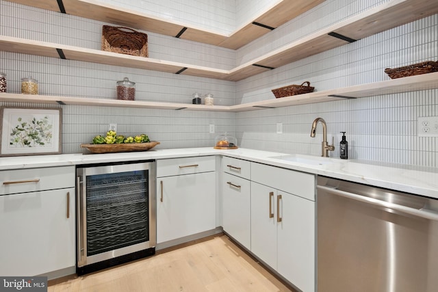 bar with wine cooler, a sink, stainless steel dishwasher, light wood-type flooring, and tasteful backsplash