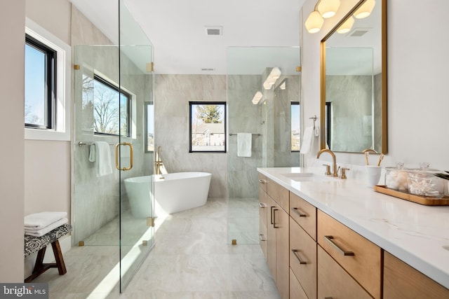 full bathroom featuring visible vents, vanity, a freestanding bath, marble finish floor, and a shower with door