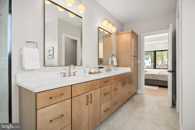 bathroom featuring ensuite bathroom, double vanity, a sink, and marble finish floor