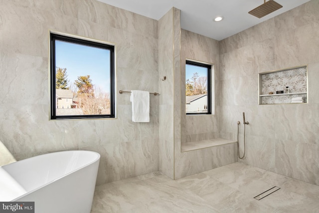 bathroom with a freestanding bath, tile walls, tiled shower, and recessed lighting