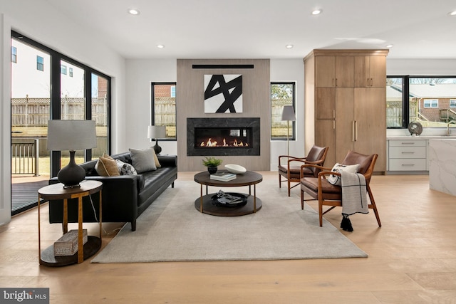 living area with recessed lighting, a healthy amount of sunlight, and light wood finished floors