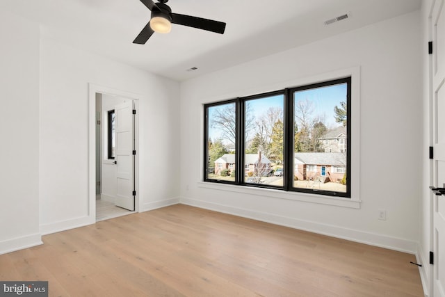 unfurnished bedroom with visible vents, light wood-style flooring, baseboards, and ensuite bathroom