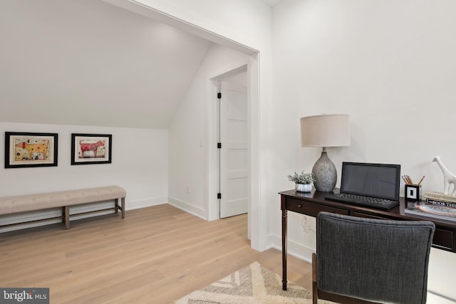 office area featuring vaulted ceiling, light wood-style flooring, and baseboards