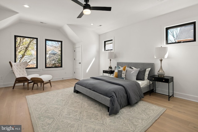 bedroom with light wood-type flooring, multiple windows, and vaulted ceiling