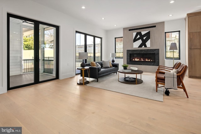 living room with light wood finished floors, a wealth of natural light, and recessed lighting