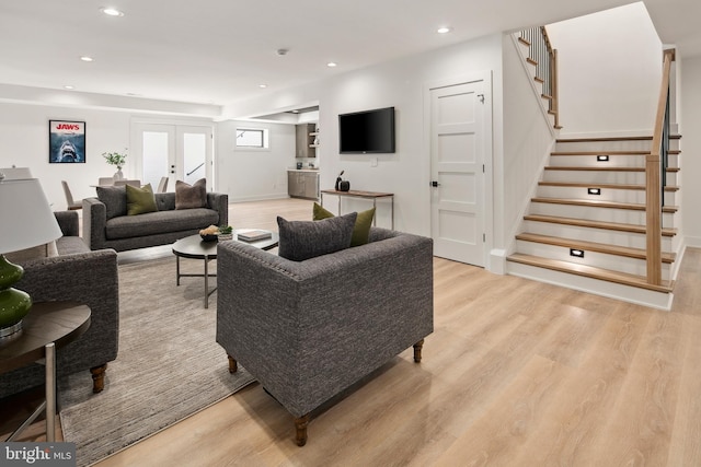 living area featuring light wood-style floors, recessed lighting, french doors, and stairs