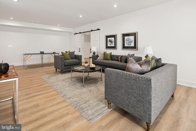 living room with a barn door, baseboards, wood finished floors, and recessed lighting