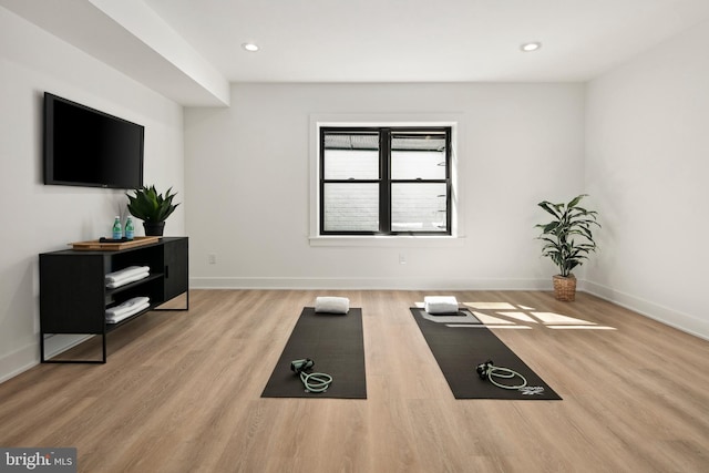 exercise room with recessed lighting, wood finished floors, and baseboards