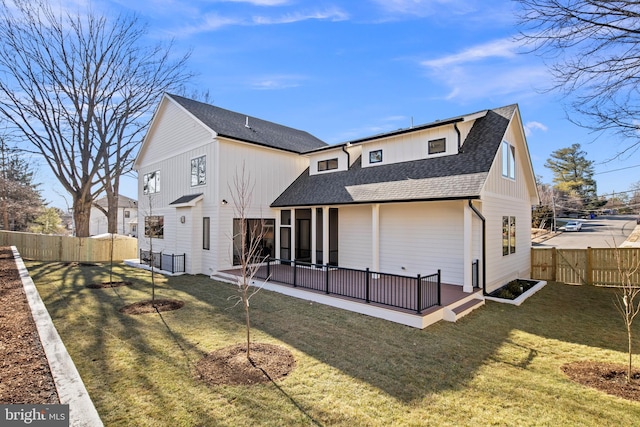 back of property with a fenced backyard, a patio, a lawn, and roof with shingles