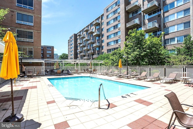 community pool with a patio and fence