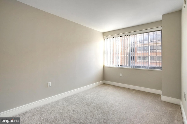 carpeted empty room with baseboards