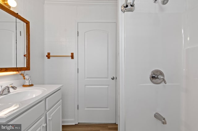 bathroom with a shower, wood finished floors, and vanity