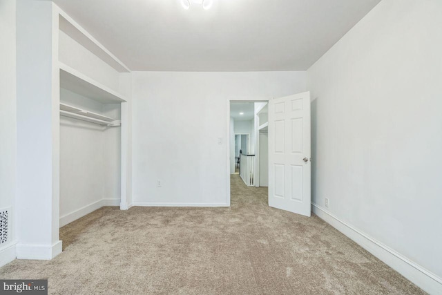 unfurnished bedroom with carpet, a closet, and baseboards