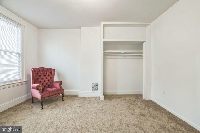 sitting room featuring visible vents, carpet, a wealth of natural light, and baseboards