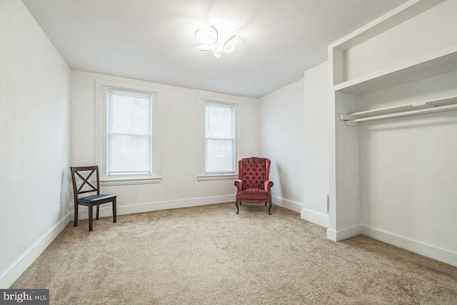 sitting room featuring carpet floors and baseboards