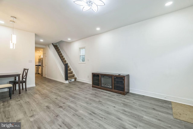 below grade area featuring stairs, recessed lighting, wood finished floors, and baseboards