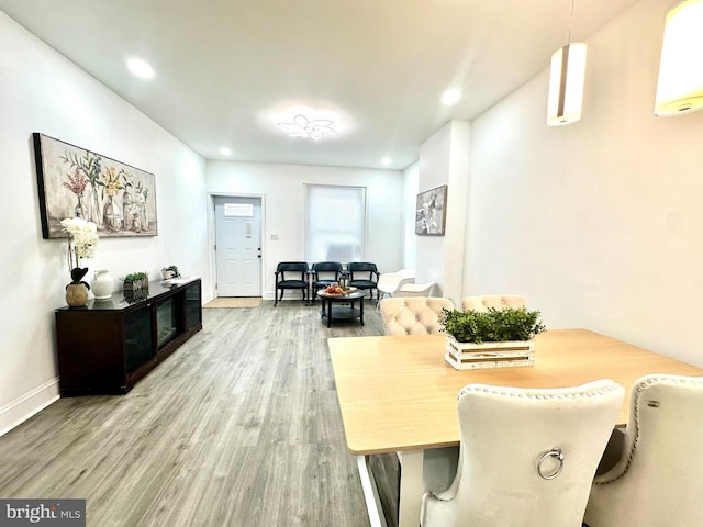 dining room featuring baseboards, wood finished floors, and recessed lighting