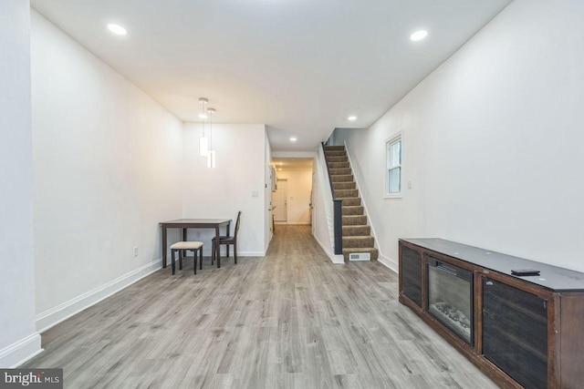 interior space featuring light wood-style floors, stairs, baseboards, and recessed lighting