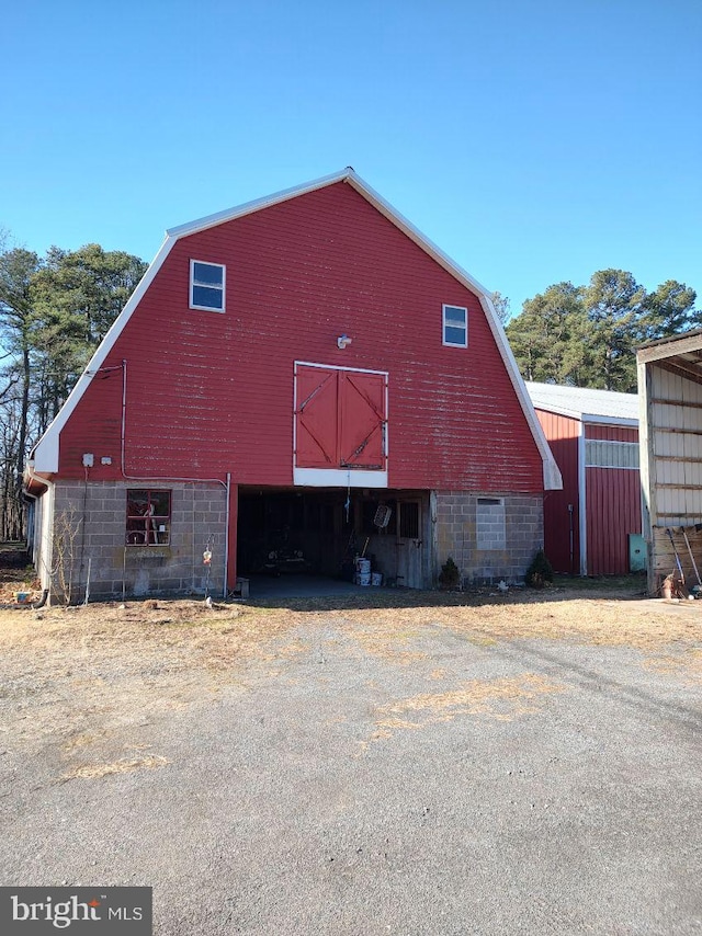 view of side of property with a barn, a garage, an outbuilding, and a gambrel roof