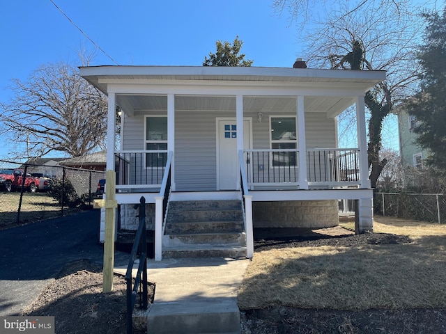 view of front of house featuring covered porch and fence