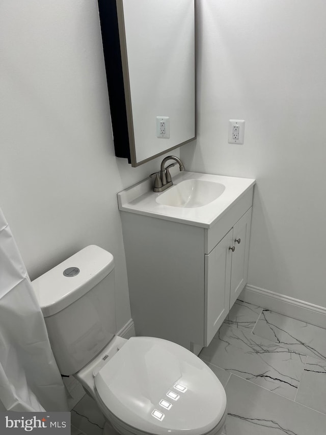 half bath featuring marble finish floor, vanity, toilet, and baseboards