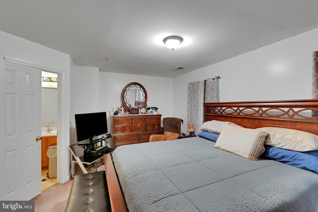 bedroom featuring connected bathroom, visible vents, and light colored carpet