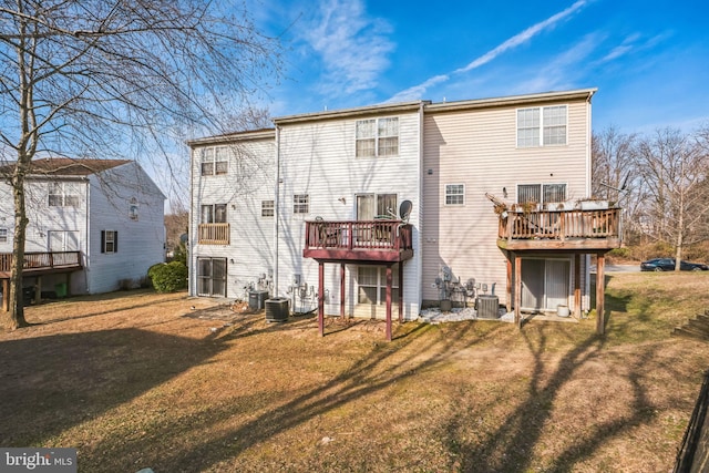 rear view of property with a lawn, a wooden deck, and central AC unit