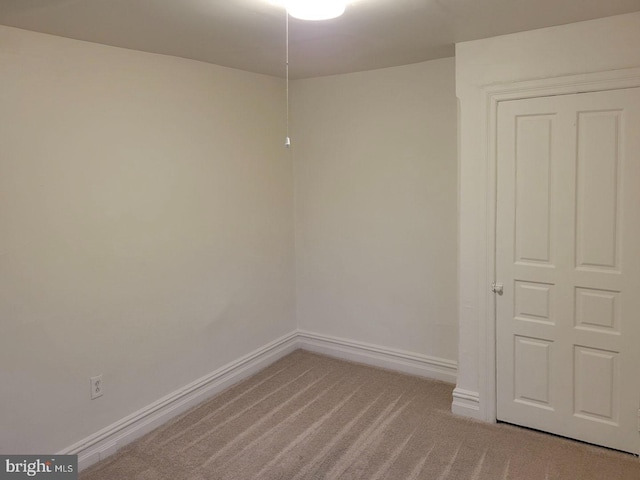 carpeted spare room featuring baseboards