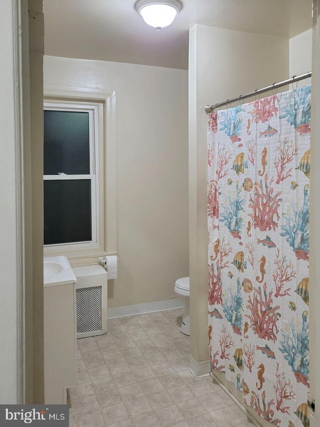 bathroom featuring a shower with shower curtain, toilet, vanity, baseboards, and tile patterned floors