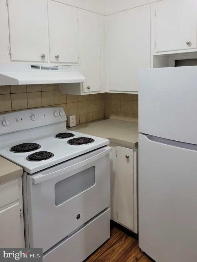 kitchen with under cabinet range hood, white appliances, white cabinets, light countertops, and backsplash