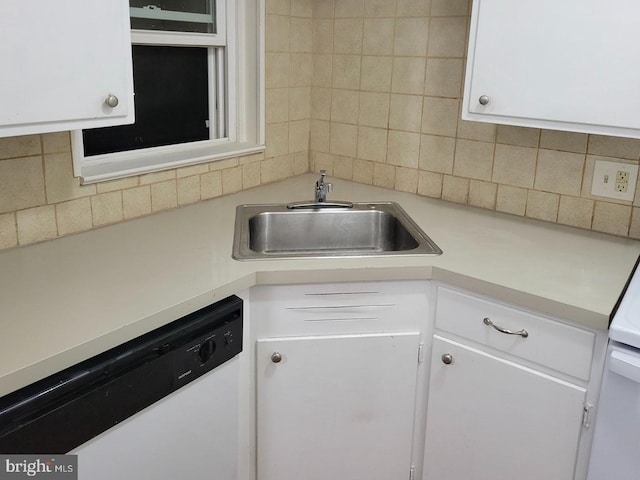 kitchen featuring light countertops, white dishwasher, a sink, and white cabinetry