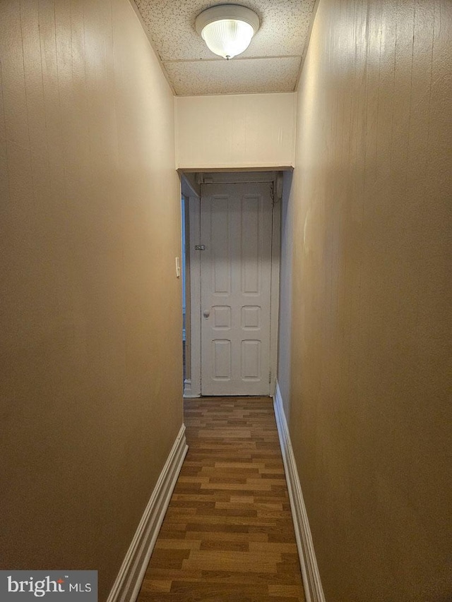 hallway with dark wood-style floors and baseboards