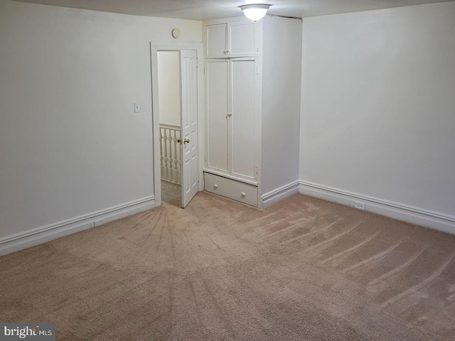 unfurnished bedroom featuring light colored carpet and baseboards