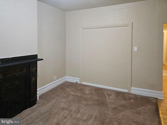 interior space with carpet, baseboards, and a textured ceiling